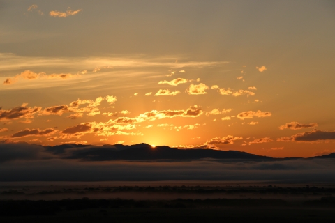 A red foggy sunrise over distant mountains.