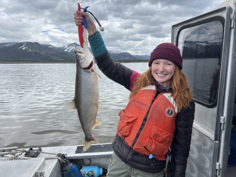 Woman holding lake trout caught on Yellowstone Lake 