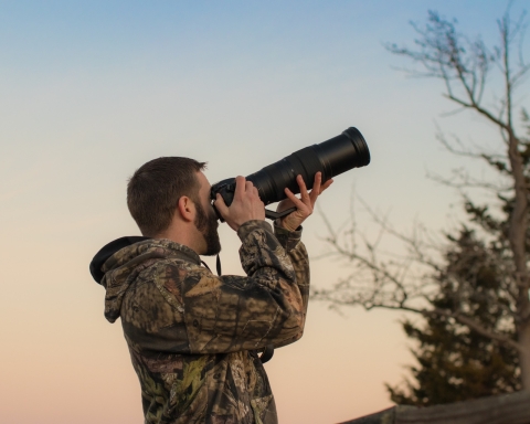 Man taking pictures of wildlife as the sun goes down in Western Maryland. 