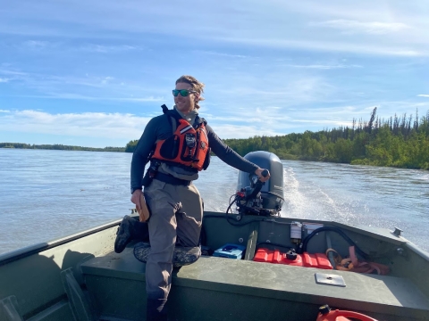 Tim Ericson, standing in a jet boat and wearing an orange life vest, steers on the Susitna River.