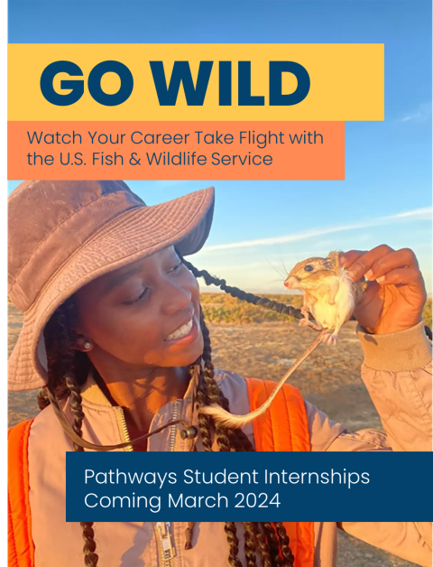 FWS intern smiles and holds a field mouse