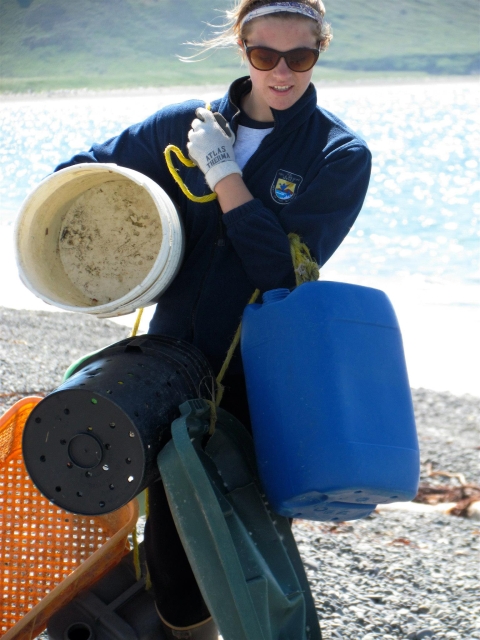 A woman carrying marine debris on a beach
