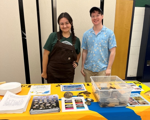 two Americorps interns at an education and outreach table 