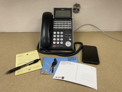Black telephone on a brown desk