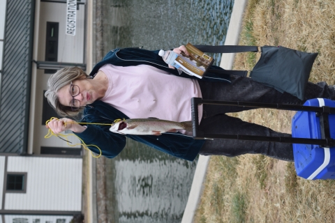 A happy female angler, smooches her rainbow trout