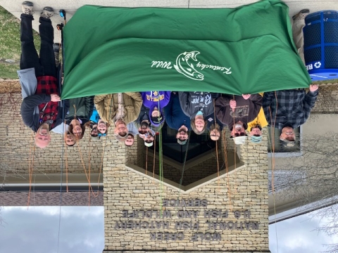 Group of anglers holding banner