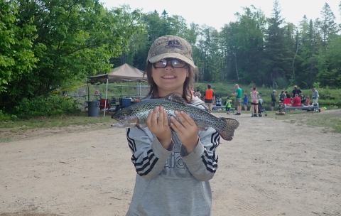 young angler holding a rainbow trout.