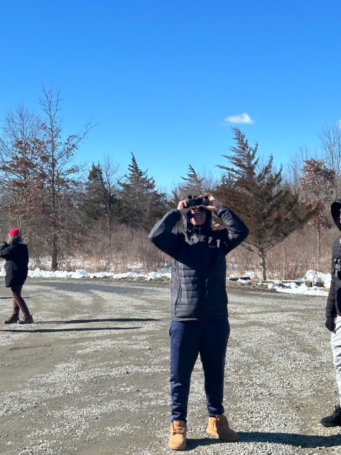 Shakil Sims of Groundwork Elizabeth looks through binoculars to search for birds as part of the 2024 Great Backyard Bird Count at Great Swamp National Wildlife Refuge
