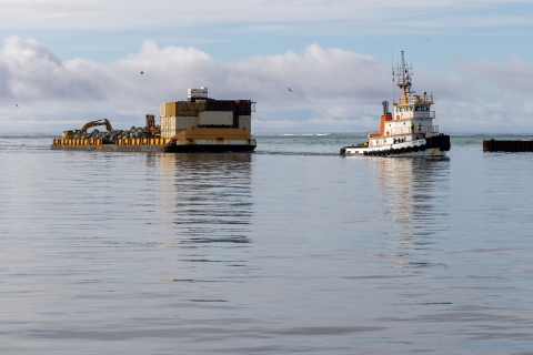 Tugboat coming into harbor with barge