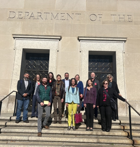 Group photo of Theodore Roosevelt Genius Prize Advisory Council members, Service staff, and prize competition winners taken in front of the Stewart Lee Udall Building in Washington, DC. 
