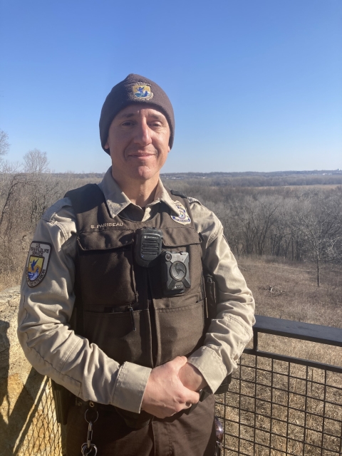 A man wearing the uniform of a U.S. Fish and Wildlife Service federal wildlife officer faces the camera.