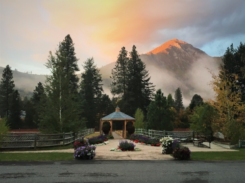 Hatchery gazebo and historic Foster-Lucas ponds at dawn with pine trees, mist, and mountains in the background.