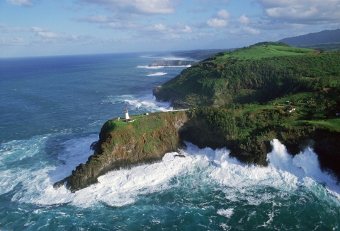A lighthouse sits on a 180 foot high peninsula surrounded by the pacific ocean