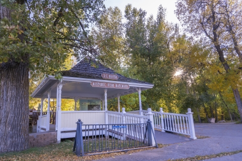 A Gazebo with a sigh reading DC Booth Historic Fish Hatchery, surrounded by trees in early fall colors