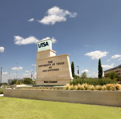 The main campus sign for the University of Texas at San Antonio is pictured in front of a blue sky.