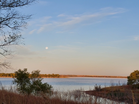 The moon sets over Foss Lake at Washita National Wildlife Refuge