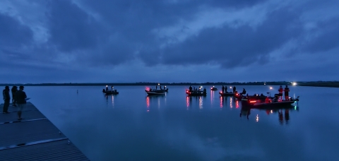 Boats on lake with lights reflecting in water