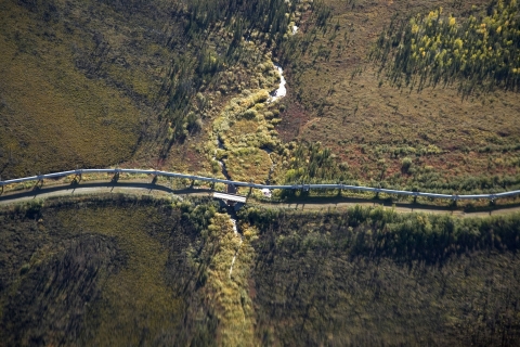 Aerial view of an oil pipeline crossing a small tributary in the Alaskan wilderness.