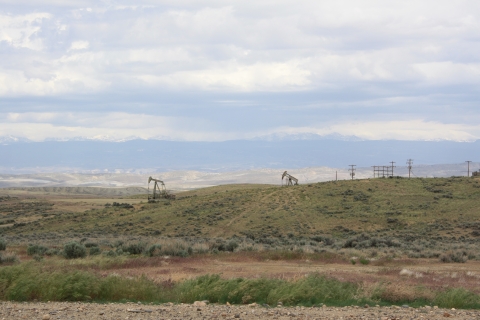 Distant view of oil pump jacks and rolling hills.