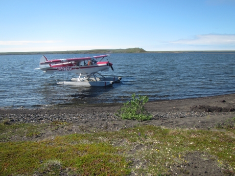 Red and white aircraft on lake