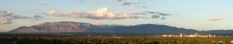 a panoramic view of downtown Albuquerque and the Sandia Mountains