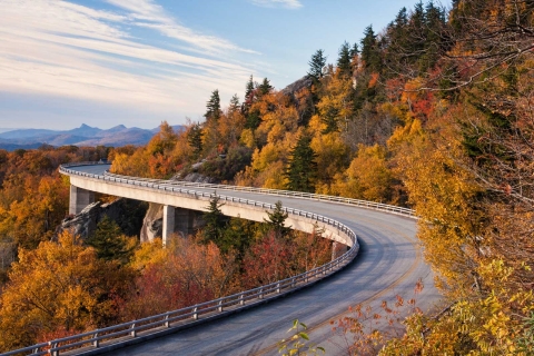 A colorful fall scene with a road cutting through.