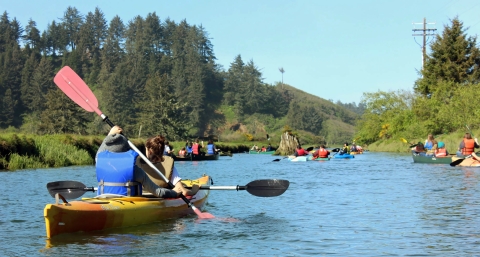 Guided water tour on a river with people in canoes.