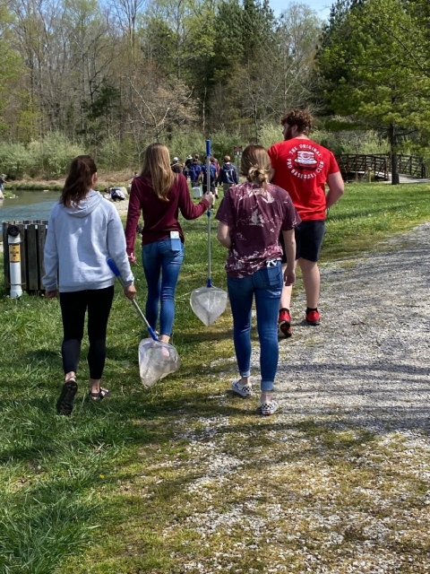 Students with nets walking by a creek 