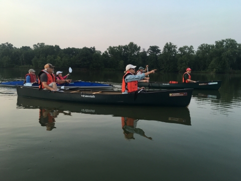 Visitors in two canoes and a kayak drift on the backwaters of the Mississippi River