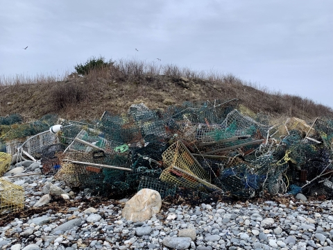 mangled pile of abandoned lobster traps on rises up to three feet on the shore of a remote sea island