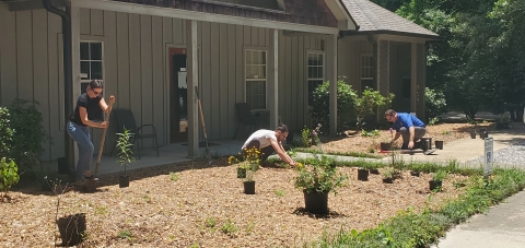 Three Alabama ES employees planting the first batch of plants in the office garden. 
