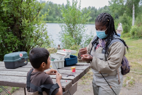 woman showing a bow how to set up a fishing bait