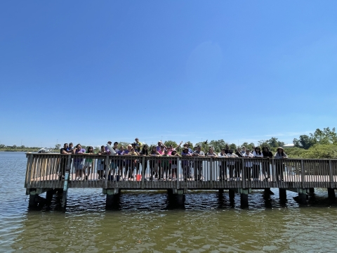 a group of people stand on a fishing pier 