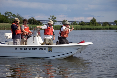 FWS employees on boat in water training for MOCC