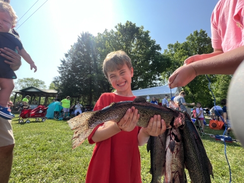 Photo of young angler holding up the fish he caught during the Wolf Creek National Fish Hatchery Catch-a-Rainbow Derby