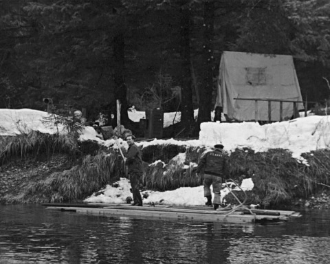 Two men building a structure on river