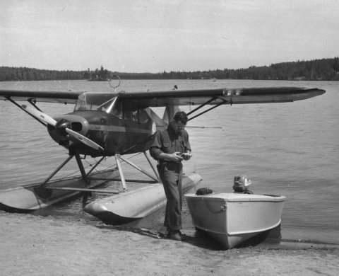 Man next to float plane on shoreline