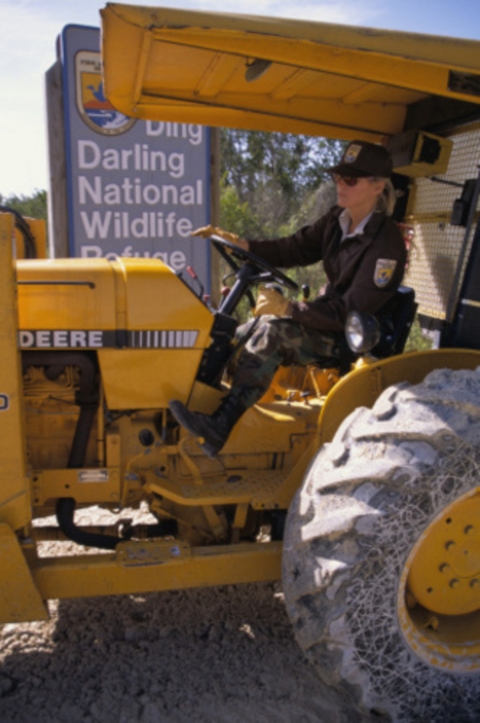 Close view of Fish and Wildlife Service worker driving large equipment