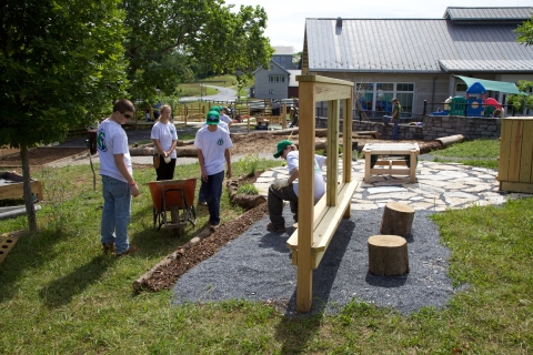 Five young people gardening in an outdoor classroom.