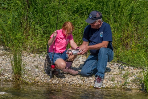 Older man with young girl with rainbow trout
