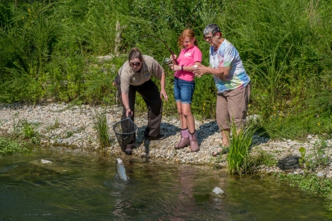 Service employee netting trout caught by young girl