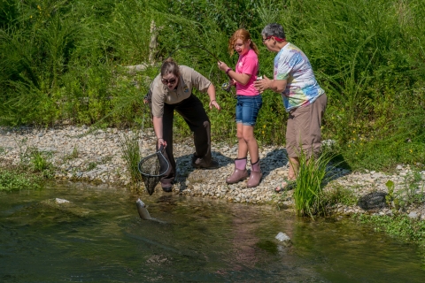 Service employee netting trout caught by young girl