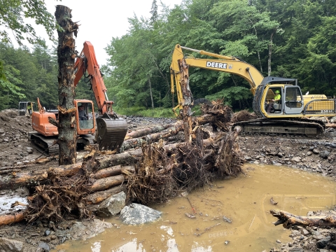 Heavy machinery moving large logs to be a part of an engineered log jam (ELJ) on the Narraguagus River in Beddington, ME.