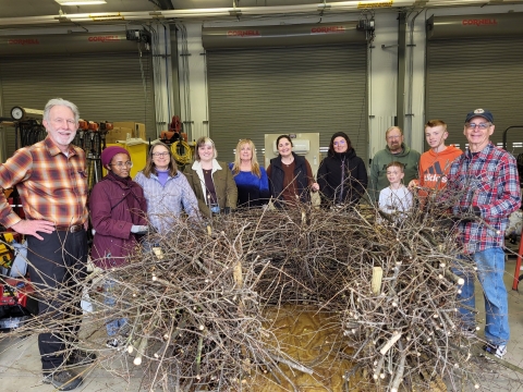 Group building the life-size bald eagle nest out of elm branches from NCTC’s campus.