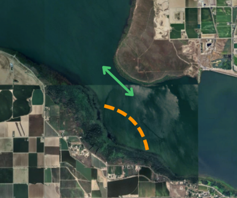 A satellite view of a lake with two symbols located on the narrowest section of the lake. A text box on the side that reads: Narrows of Lake Lowell. No wake zone is displayed as a dashed orange line and new passage is displayed as a green two-way arrow. Both symbols displayed on map.