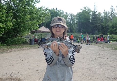 young person holding a rainbow trout