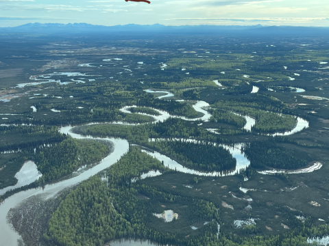 aerial view of a river winding through forests across the landscape
