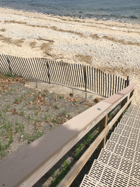 Stairs lead down to a sandy beach