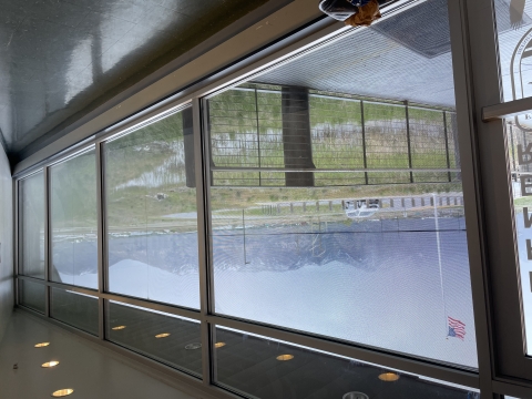 view facing out ceiling-high windows at snowy mountains and an overcast sky