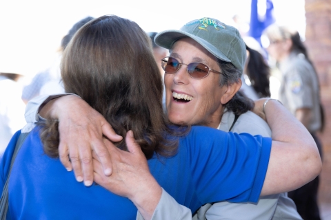 Two women hug each other at an outdoor event